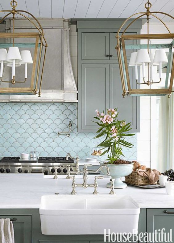 Fish Scale tiles via House Beautiful in seafoam green with oversized lantern style ceiling fixtures at the kitchen island